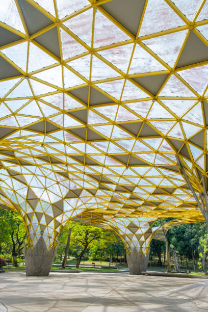 istock Modern architectural structure with yellow geometric roof and large open space surrounded by greenery and trees in Perdana Botanical Garden, Kuala Lumpur, Malaysia, Asia. Vertical orientation 2179948500