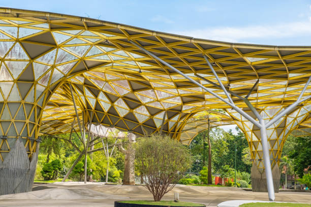 istock Perdana Botanical Garden, Kuala Lumpur, Malaysia with modern architectural structure with a yellow geometric roof and large open space surrounded by greenery and trees under a bright blue sky 2179948901