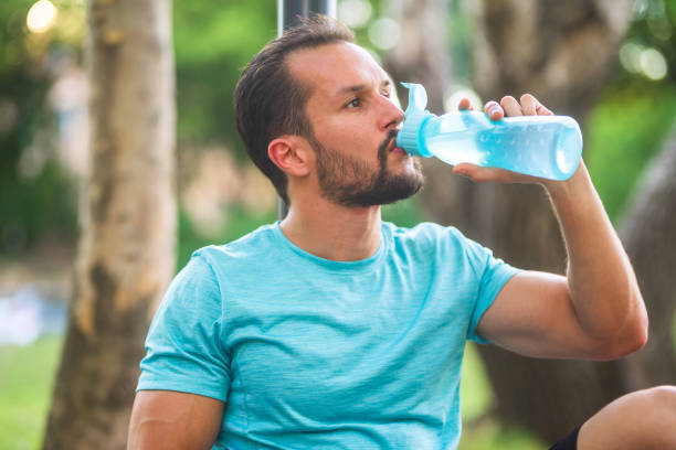 istock Young sportsman drinking water from bottle after training in park 2179950911