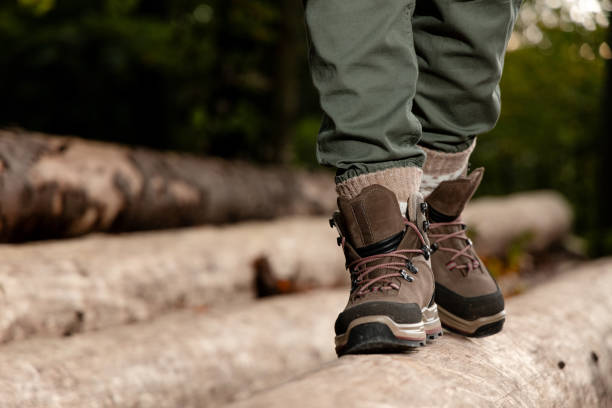 Woman balancing on a log while walking in the forest