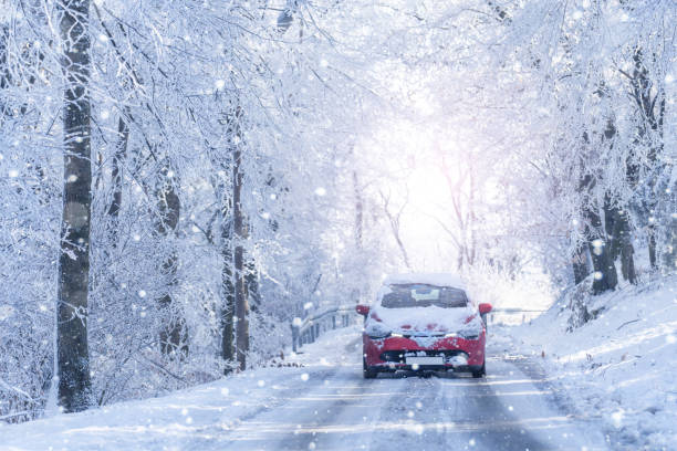 istock Car on a winter road through a snow covered forest 2179956357