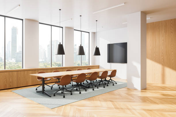 istock A modern conference room featuring a long wooden table, chairs, large windows, and hanging lights. Bright interior with cityscape background. Concept of business and coworking. 3D Rendering 2179956625