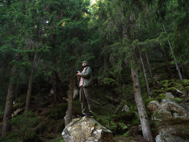 istock Confident Photographer Standing on Rock in Dense Forest 2179957289