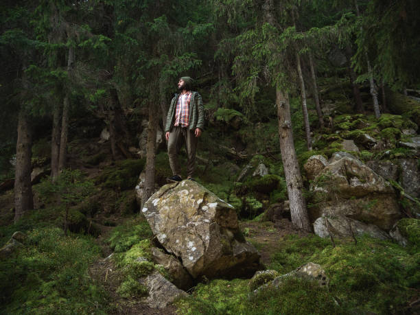 istock Adventurous Hiker Standing on Rock in Dense Forest 2179957395