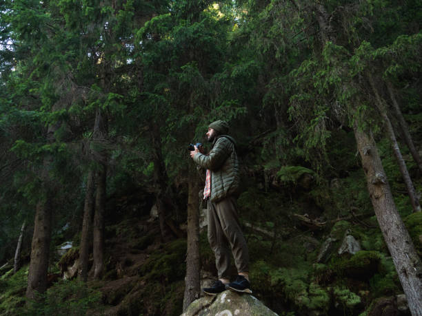 istock Photographer on Rock Capturing Forest's Beauty 2179957975