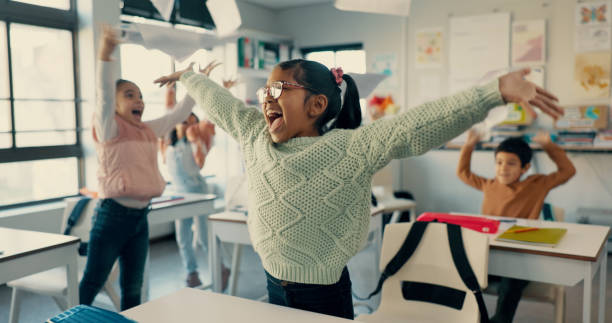 istock Excited students, kids and celebration with documents in air for holiday, summer or end of school semester. Young, happy and elementary children with smile for recess, done or finished in classroom 2179961134
