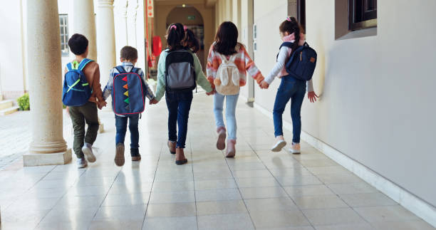 istock Kids, holding hands and group with back at school with care, connection and support in hallway. Children, friends and together with bonding, education and development with scholarship at academy 2179961253