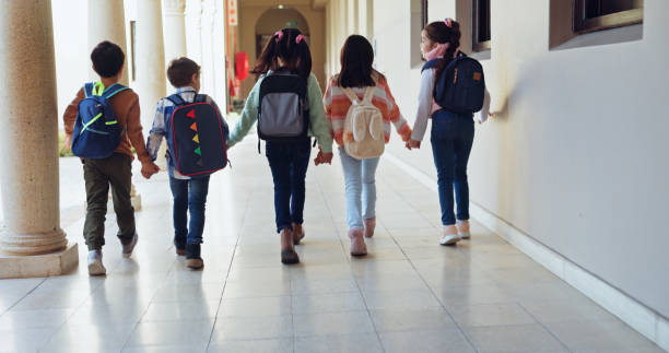 istock Children, holding hands and group with back at school with care, connection and support in hallway. Kids, friends and together with bonding, education and development with scholarship at academy 2179961271