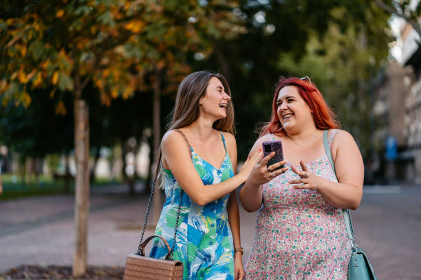 istock Two Female Friends Using Smart Phone In The Park 2179961372