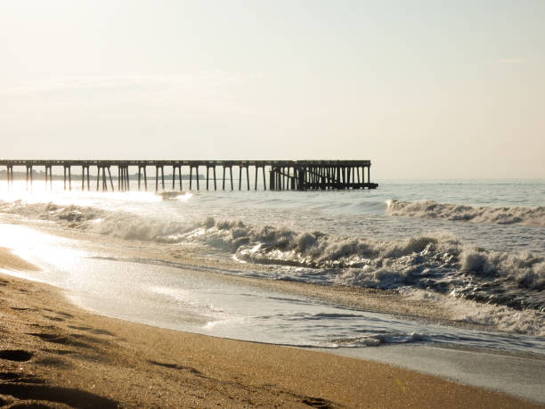 istock Waves crashing onto the beach with a pier in the background 2179961842