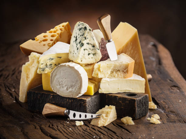 istock Variety of different cheese chunks on wooden table close up.. 2179965294
