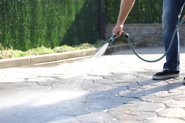 istock Man cleaning garden floor with water using hosepipe 2179965384