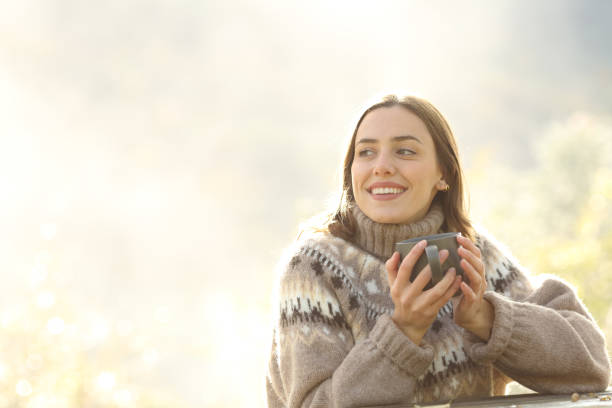 istock Happy woman in winter drinking coffee in a park 2179965559