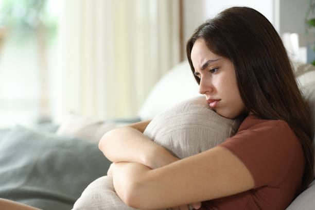 istock Sad woman complaining hugging pillow at home 2179965673