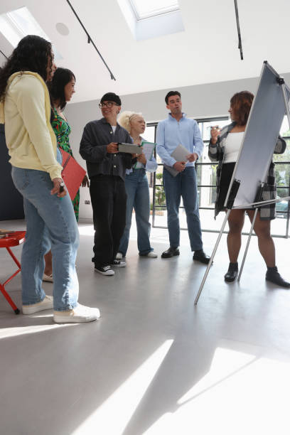 istock People standing and looking at whiteboard during meeting 2179966588