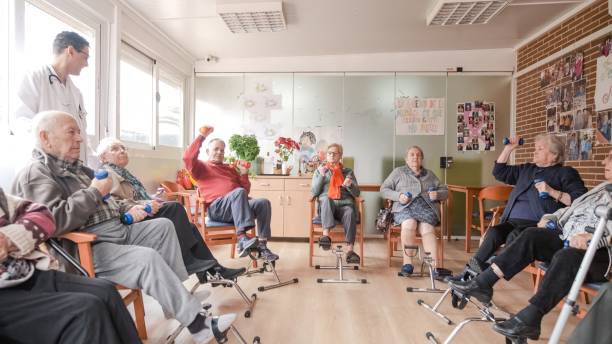 istock Friendly caregivers watching senior people exercising at nursing home 2179972955