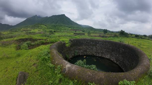istock Medieval Well in a Lush Meadow Surrounded by Mountains 2179973017