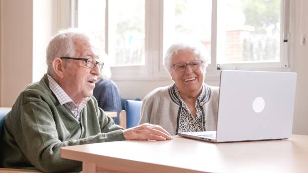 istock Happy senior couple chatting online using laptop at nursing home 2179973069