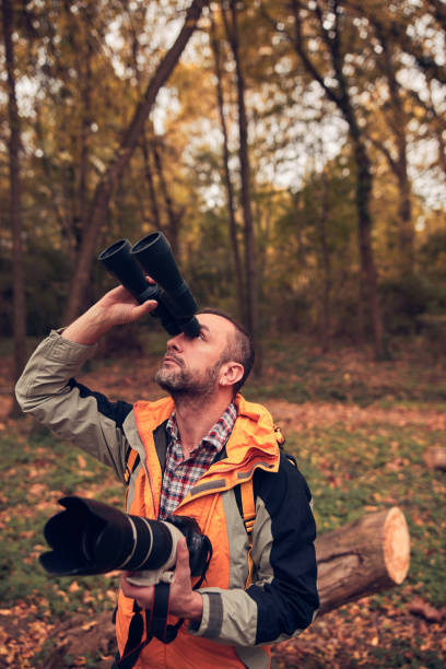 istock Man using binoculars and camera for bird and animal watching in nature. 2179974478