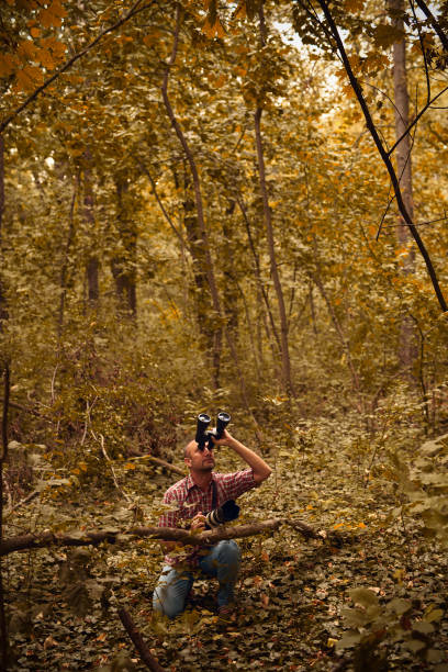 istock Man using binoculars and camera for bird and animal watching in nature. 2179974571