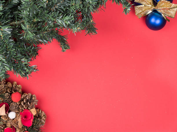 istock Beautiful Christmas wreath with christmas tree and globes on red background 2179975111