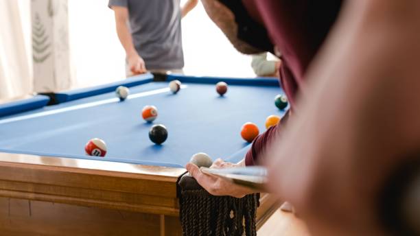 istock Anonymous man playing pool with friends in game room at home 2179976460