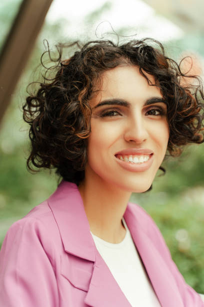 istock Young businesswoman smiling outdoors wearing pink jacket 2179976809