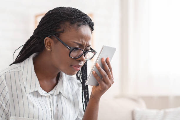 istock Young afro woman with eyesight problems looking at smartphone screen 2179984909