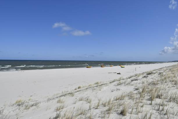 istock Serene beach scene with clear blue sky and boats 2179984948