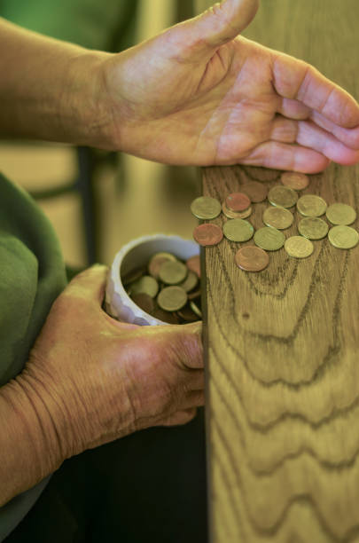 istock adult senior hands Sorting Small Change into a Container on a Wooden Table 2179985167