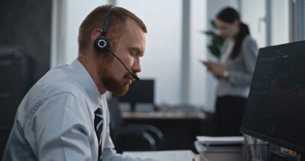 istock Financial specialist works on computer, talks to clients, monitors share markets, takes notes 2179986479