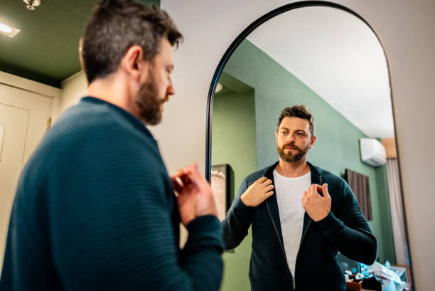 istock Mature man getting dressed in front of the mirror in a bedroom 2179987229
