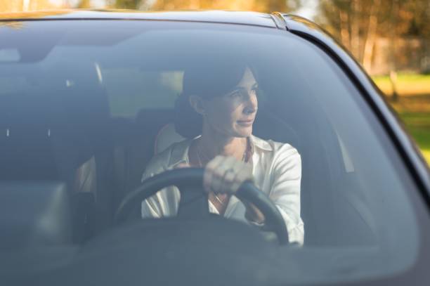istock Woman driving car with park view 2179987562