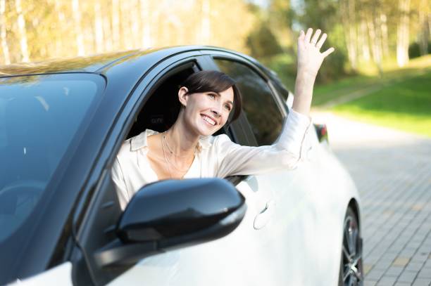 istock Woman waving from car window 2179987624