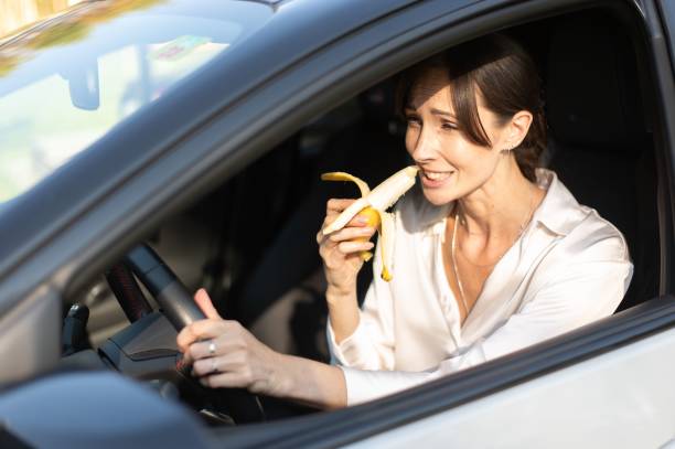 istock Woman eating banana while driving 2179987679