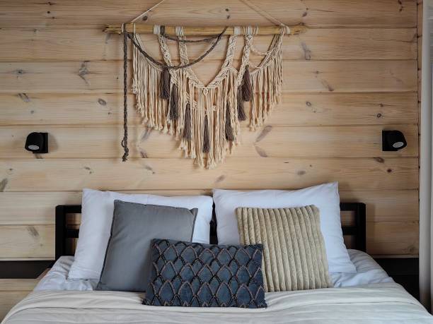 istock Cozy bedroom with decorative macrame hanging and plush pillows in a rustic wooden setting 2179989102