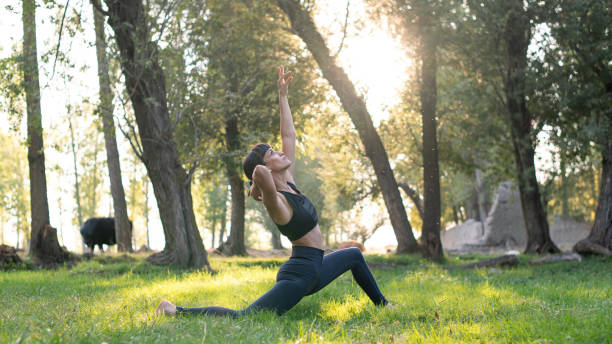 istock Woman doing yoga and stretching exercise among trees in nature 2179995639