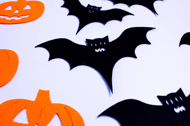 istock Black bats and orange pumpkins on white background 2179997186