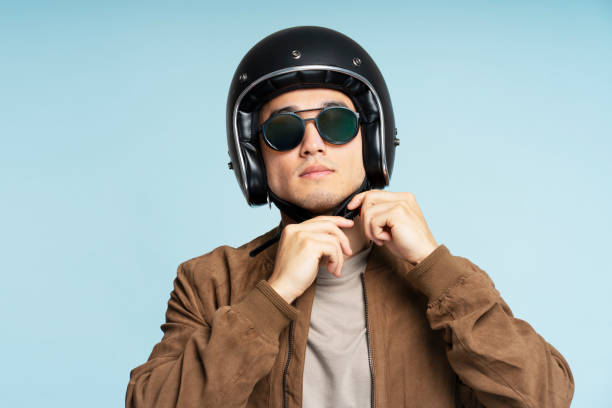 istock Handsome biker wearing sunglasses is fastening his helmet before a ride 2180000111