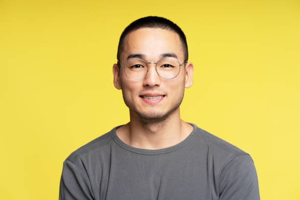 istock Asian man wearing glasses smiling on yellow background 2180000305