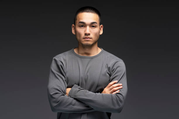 istock Serious young man is crossing his arms on a dark background 2180000510