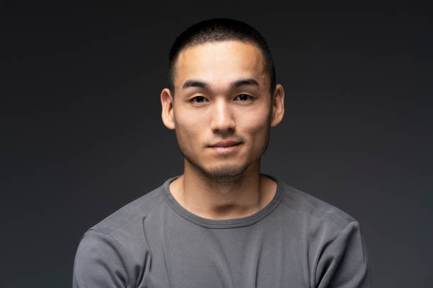 Young asian man posing on dark background