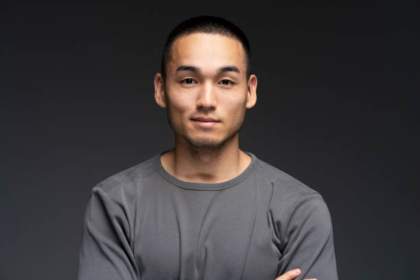 istock Young man with arms crossed posing on grey background 2180000521