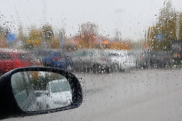 istock a rainy day scene from inside a car, where raindrops have accumulated on the windshield, blurring the view of the outside 2180000703