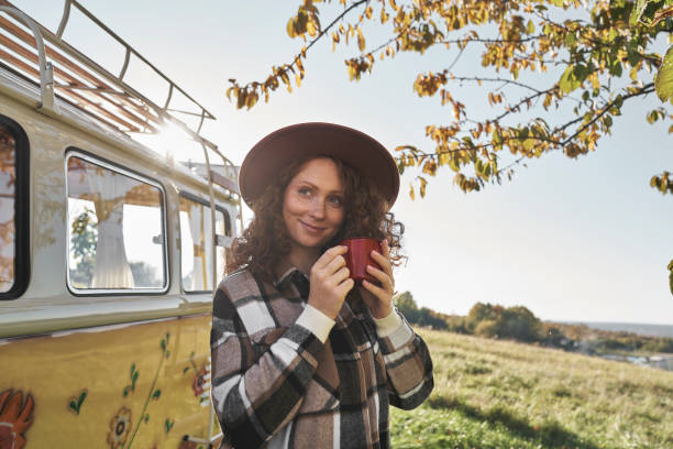 Woman with Hat and Coffee by Retro Camper Van