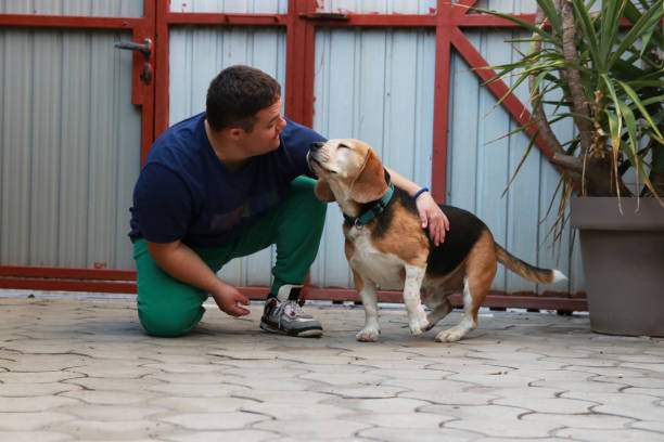 istock Young man with Down syndrome having fun with dog 2180001585