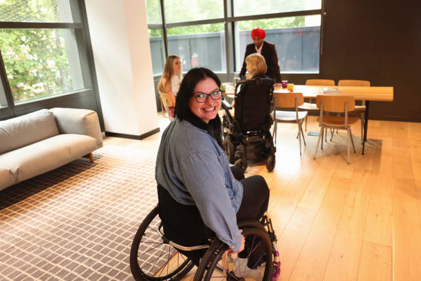 istock Woman on wheelchair moving through office 2180006207