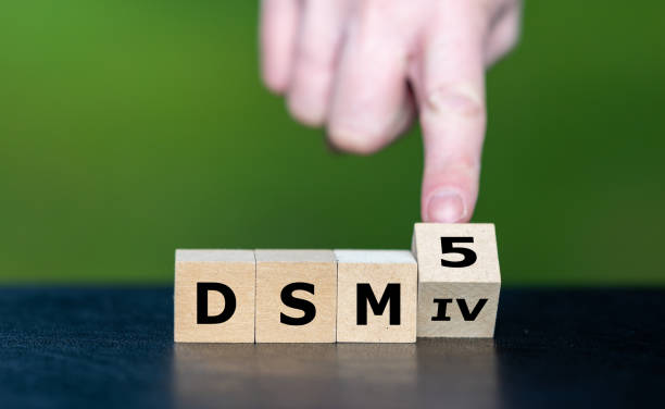 istock Hand turns cube and changes the expression 'DSM IV' to 'DSM 5'. Symbol for the update of DSM (Diagnostic and Statistical Manual of Mental Disorders) guideline. 2180012644