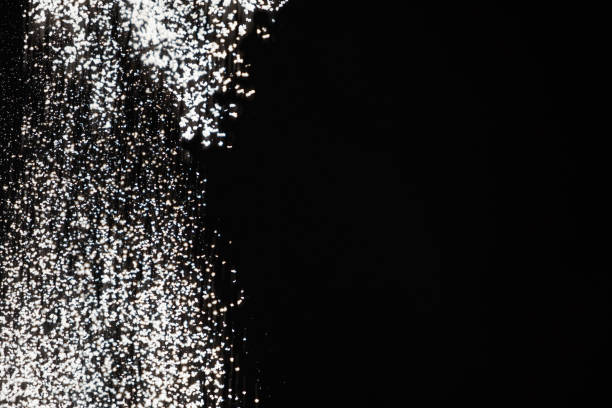 Abstract black and white background of pouring flour, space for text.