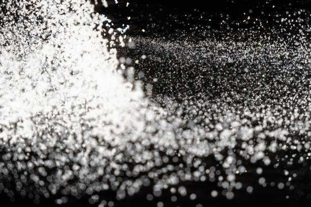 Abstract black and white background of pouring flour, space for text.